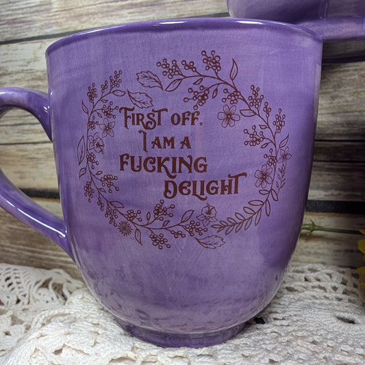 Purple mug with text and floral design on a wooden surface
