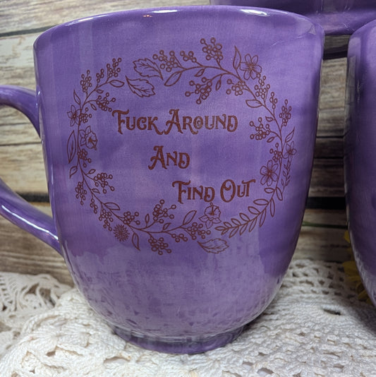 Purple mug with floral design and text on a textured surface
