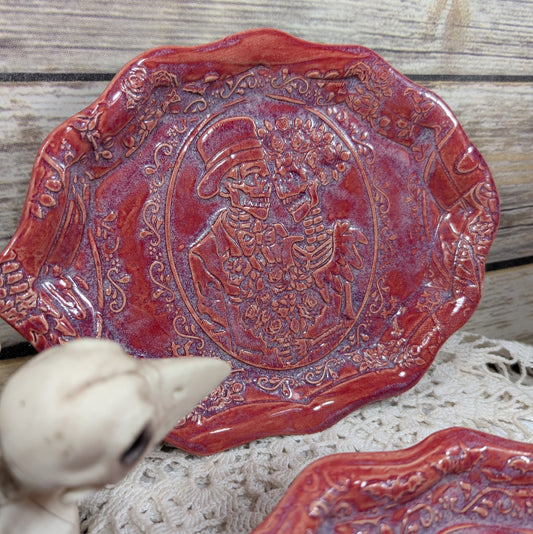 Decorative red plate with intricate designs on a wooden surface