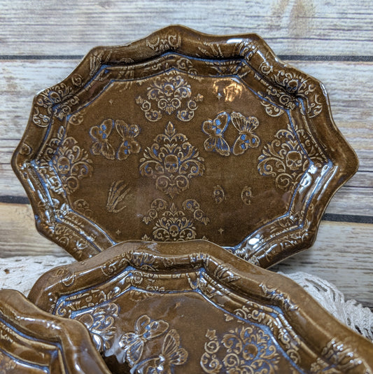 Decorative brown ceramic plates with floral patterns on a wooden surface