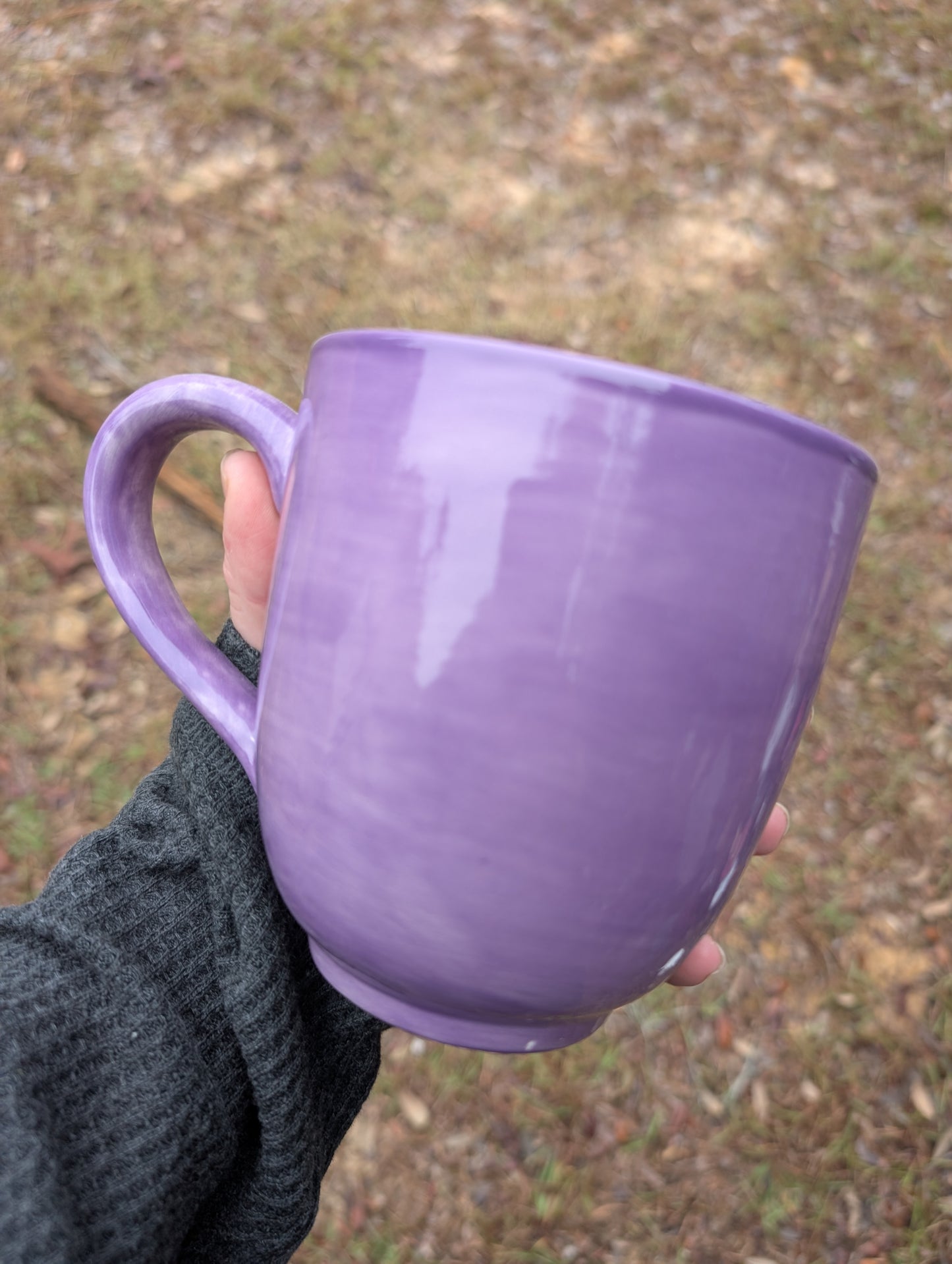 a purple mug being held in someone's hand