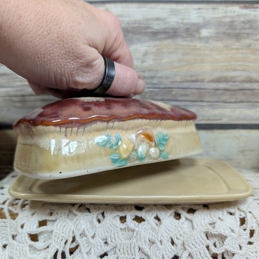 Decorative ceramic butter dish with lid on a lace tablecloth