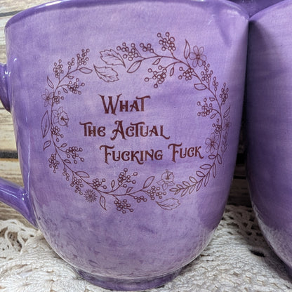 Purple mug with floral design and text on a textured surface