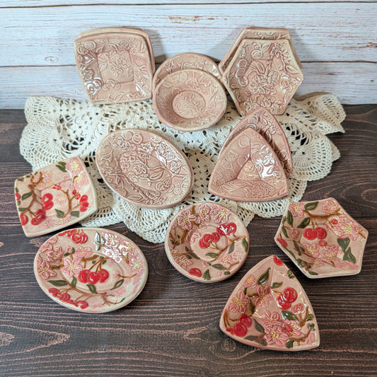 Collection of decorative ceramic items with floral patterns on a wooden surface.