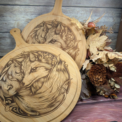 Two wooden cutting boards with fox engravings on a rustic background.