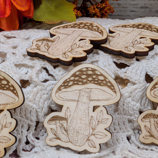 Wooden mushroom magnets on a textured fabric background