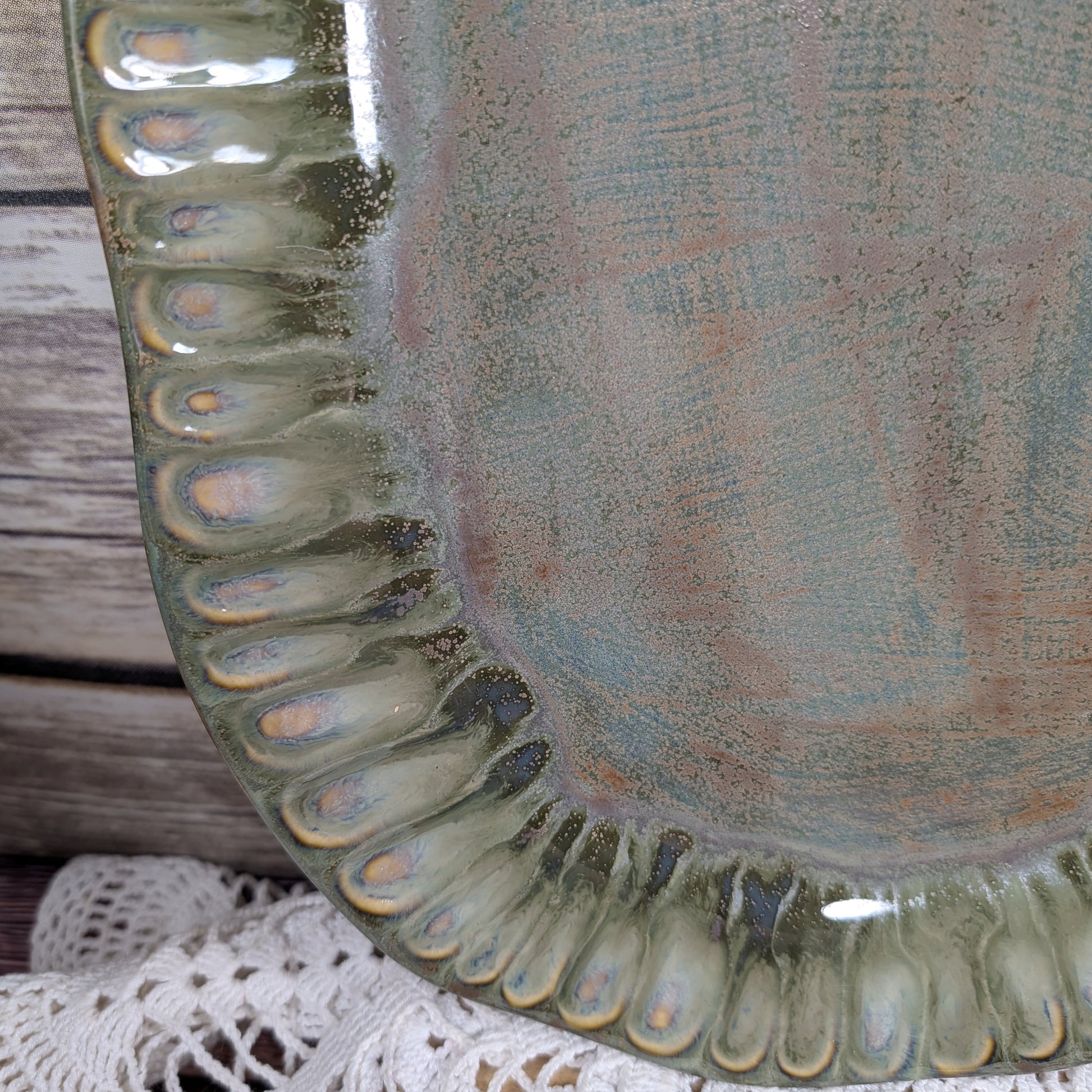 Close-up of a ceramic plate with textured edge and multicolored glaze.