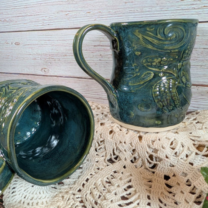 Two green ceramic mugs with textured design on a lace doily.