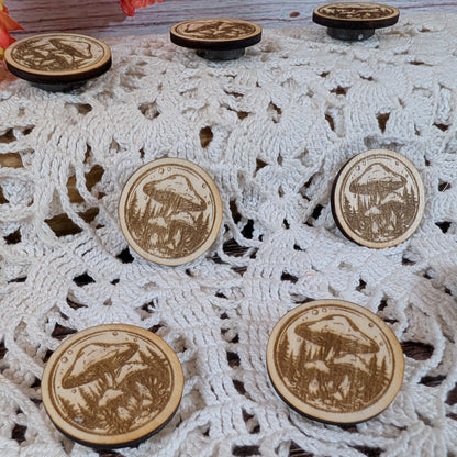 Wooden magnets with engraved mushroom designs on a lace fabric background