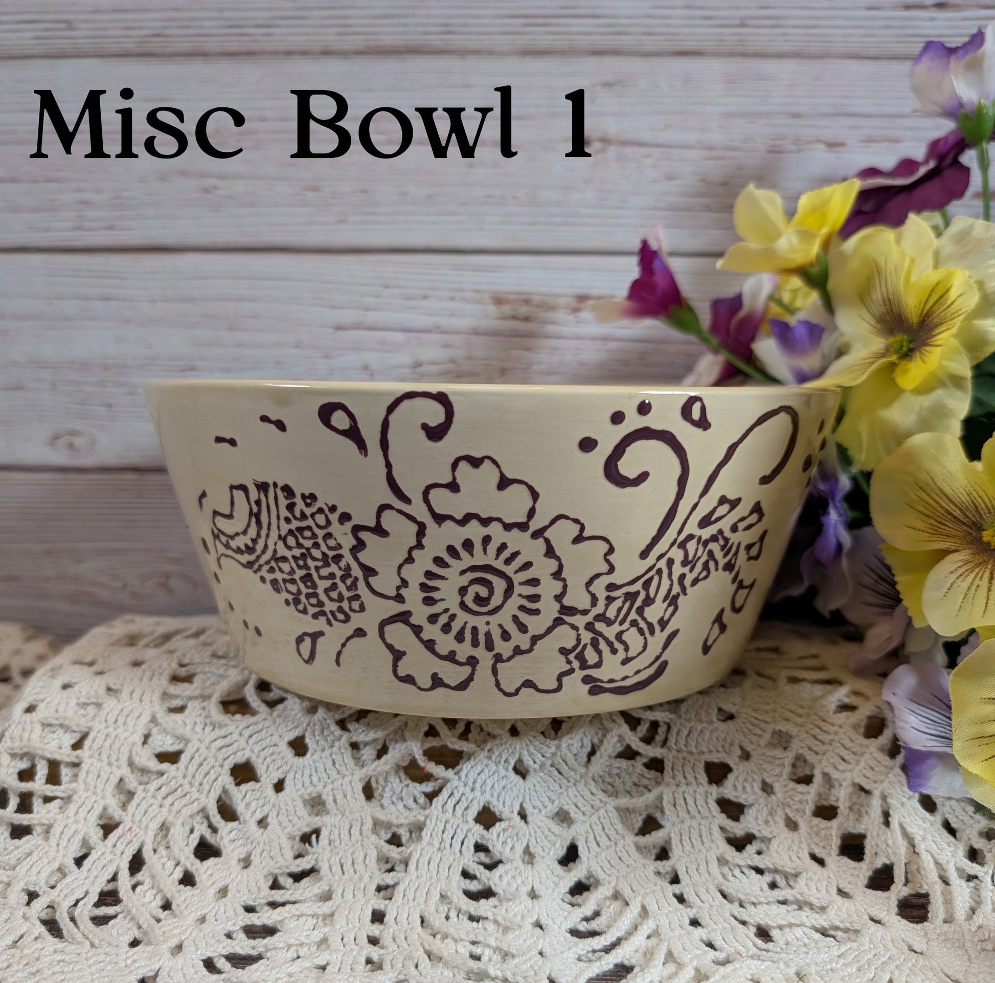 Decorative bowl with floral patterns on a lace tablecloth with flowers in the background