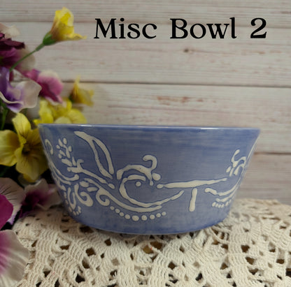 Blue ceramic bowl with white floral patterns on a lace tablecloth with flowers in the background