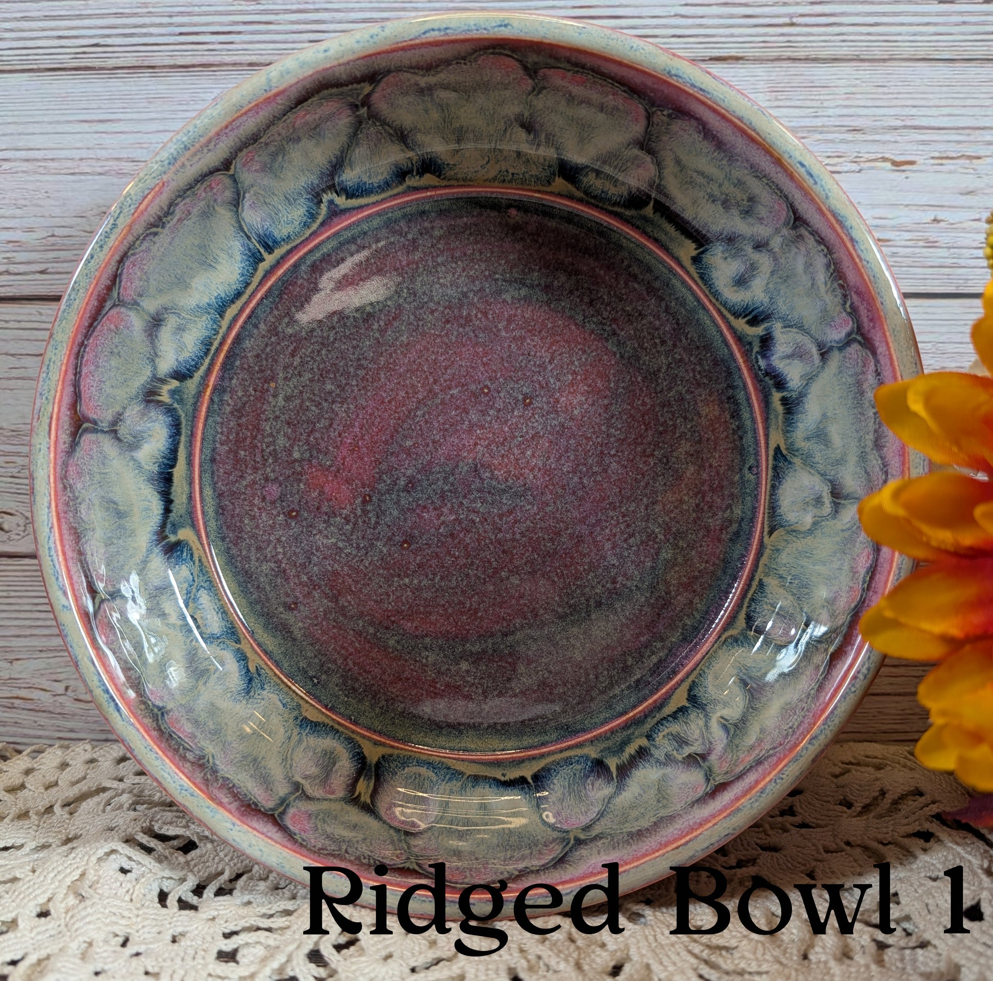 Ridged pink and gray ceramic bowl with textured surface on a wooden background