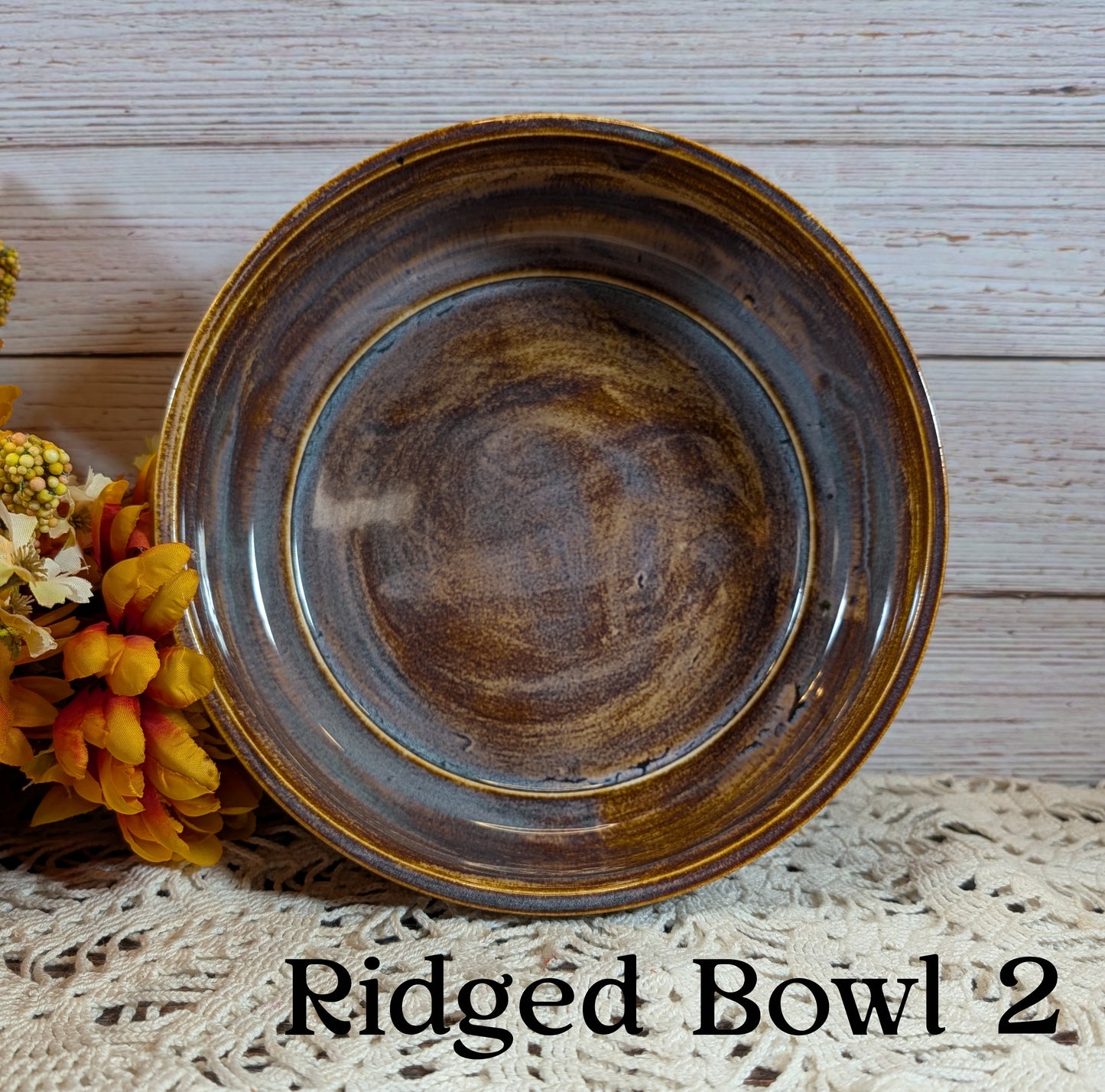 Ridged bowl labeled 'Ridged Bowl 2' on a textured surface with flowers.