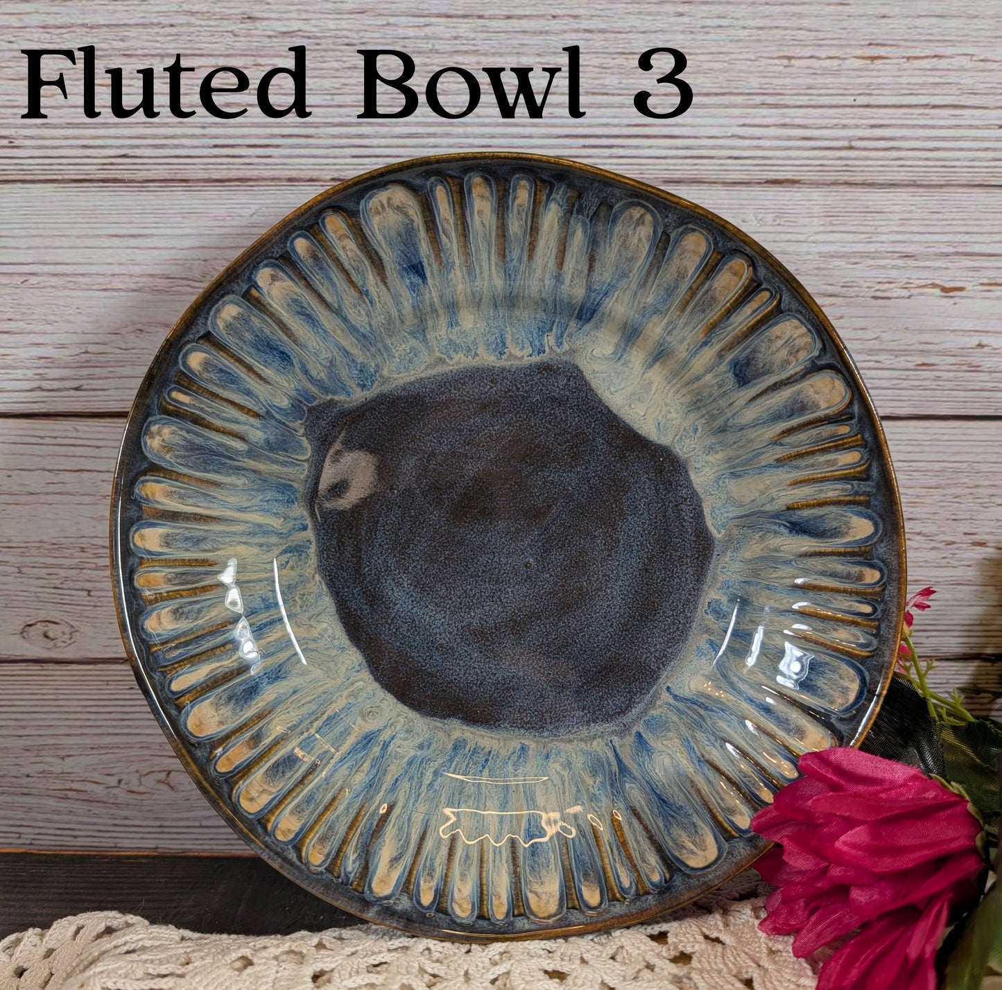 A dark blue and gray ceramic bowl with decorative edge on a wooden surface