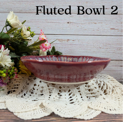 Red bowl on a lace doily with flowers and wooden background