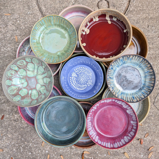 Collection of colorful ceramic bowls on a concrete surface