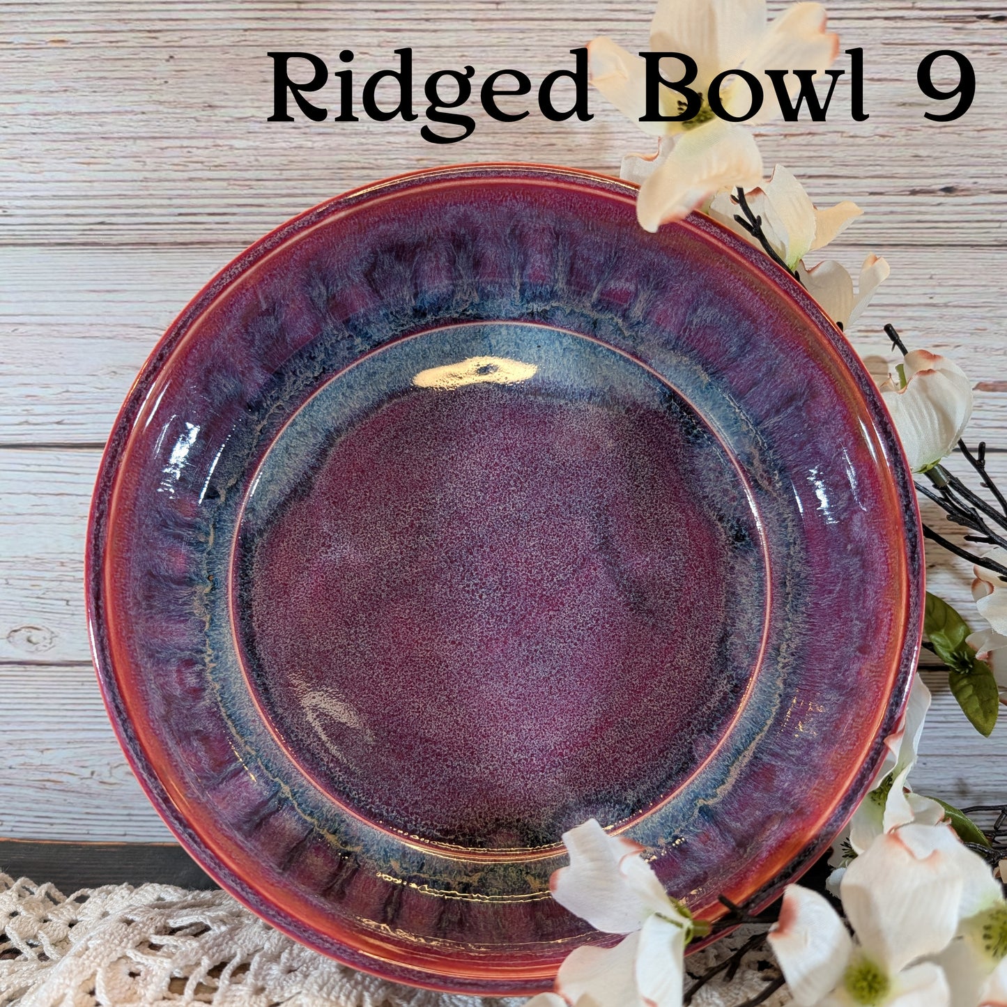 Red bowl with floral decorations on a wooden surface