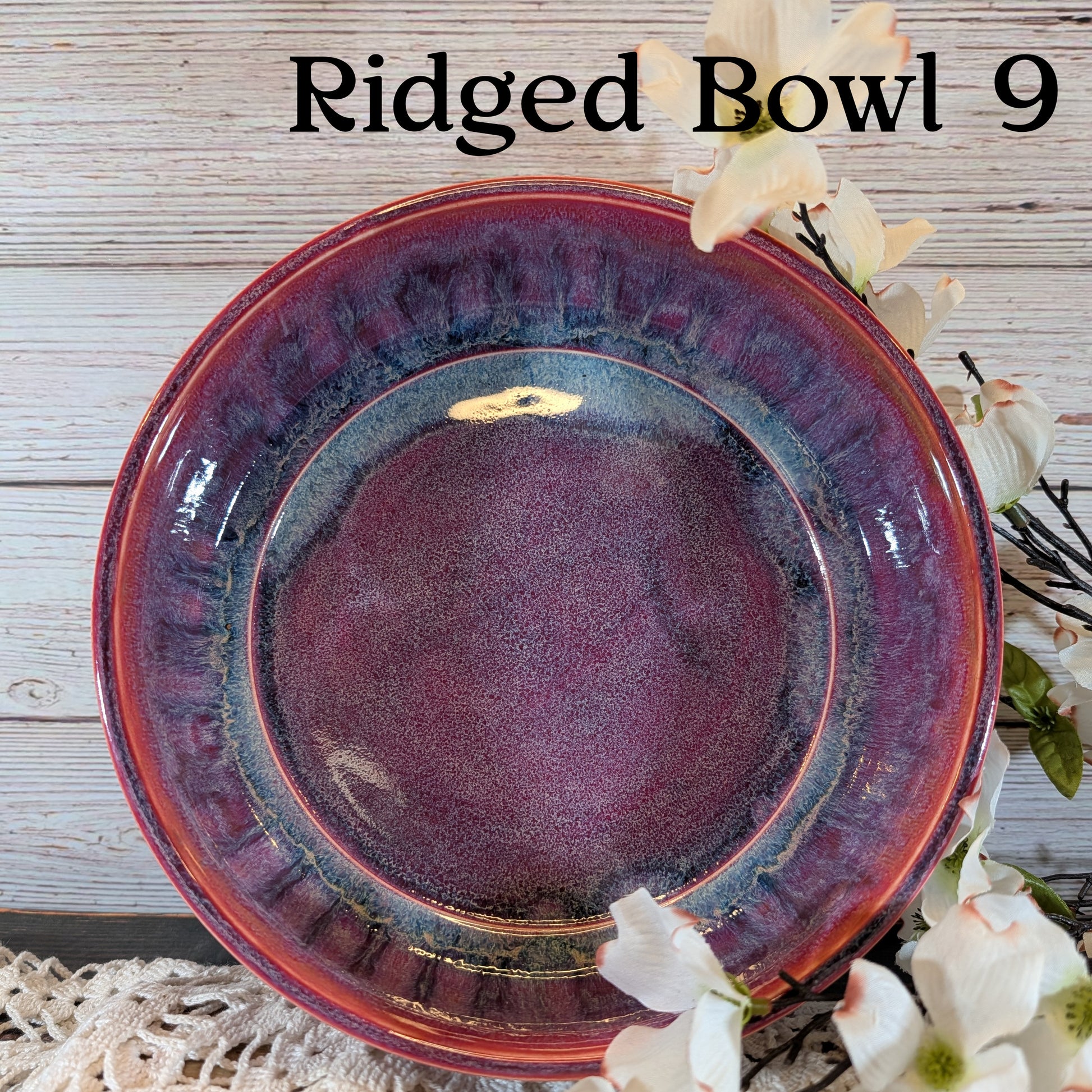 Red bowl with floral decorations on a wooden surface