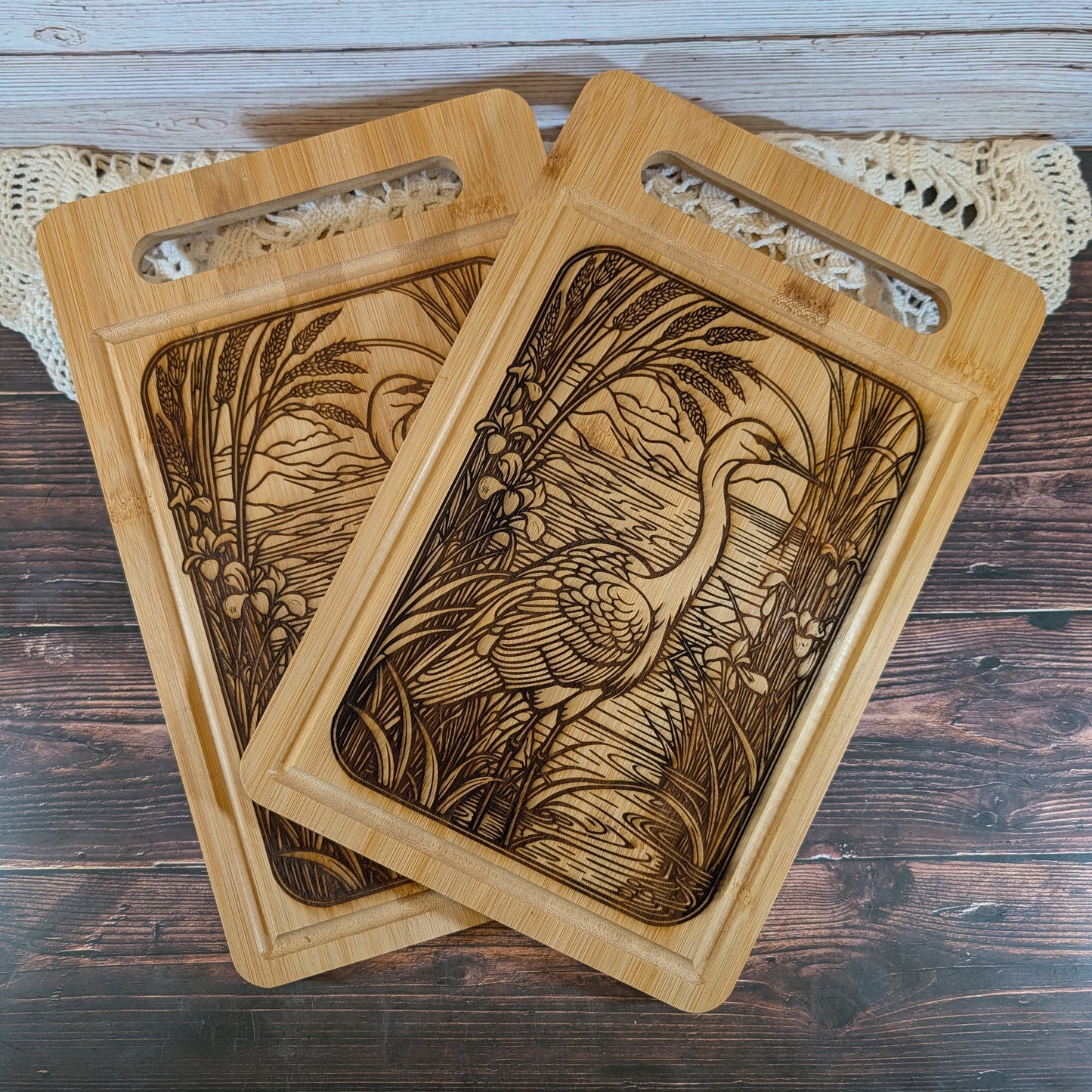 Two wooden cutting boards with engraved designs on a wooden surface.