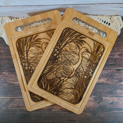Two wooden cutting boards with engraved designs on a wooden surface.